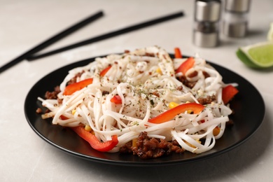 Photo of Plate with rice noodles, meat and vegetables on table
