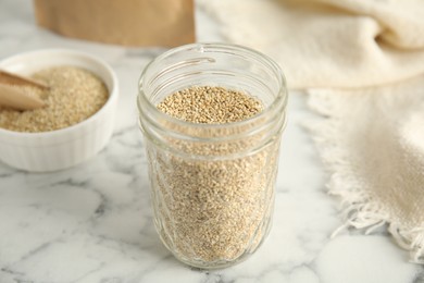 Jar with white quinoa on marble table