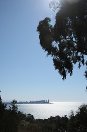 Photo of Picturesque view of beautiful sea and distant city under blue sky