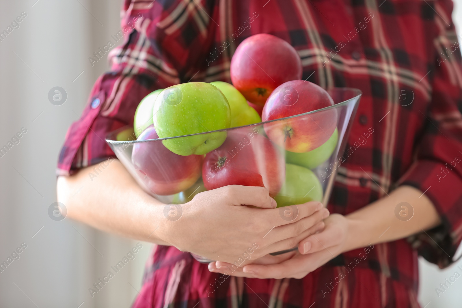 Photo of Woman holding bowl with ripe apples, closeup