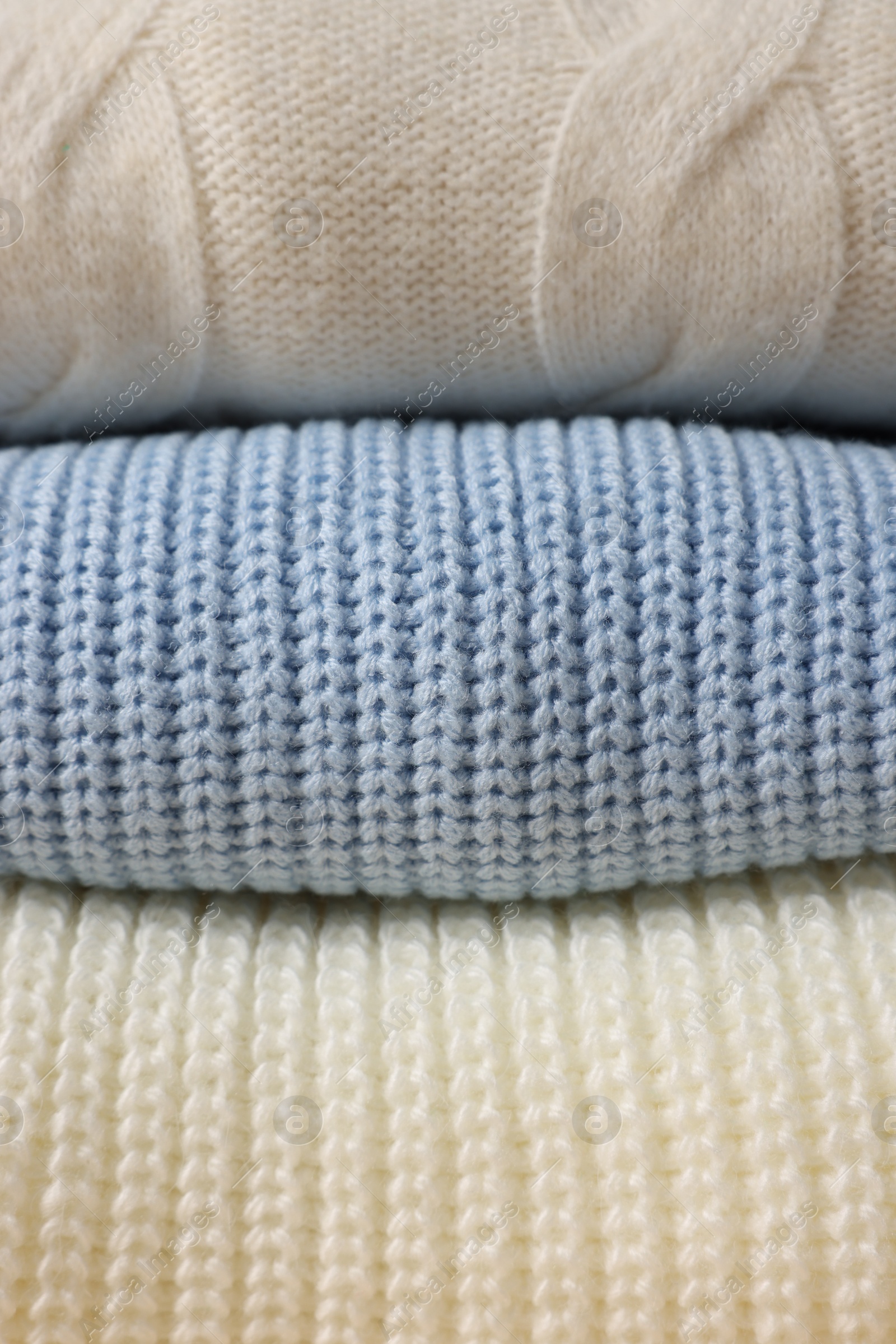 Photo of Stack of casual warm sweaters as background, closeup view