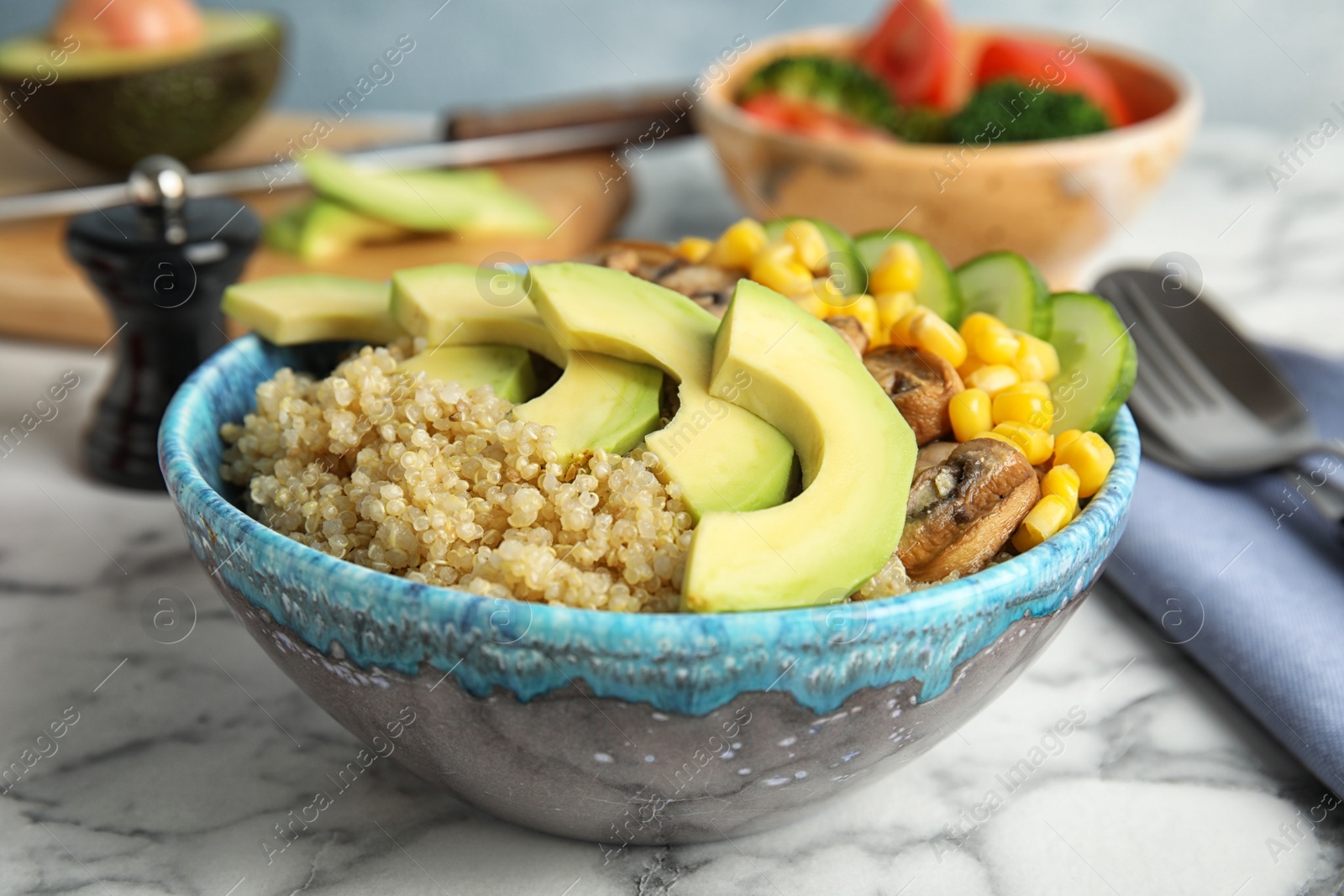 Photo of Bowl with quinoa and garnish on table