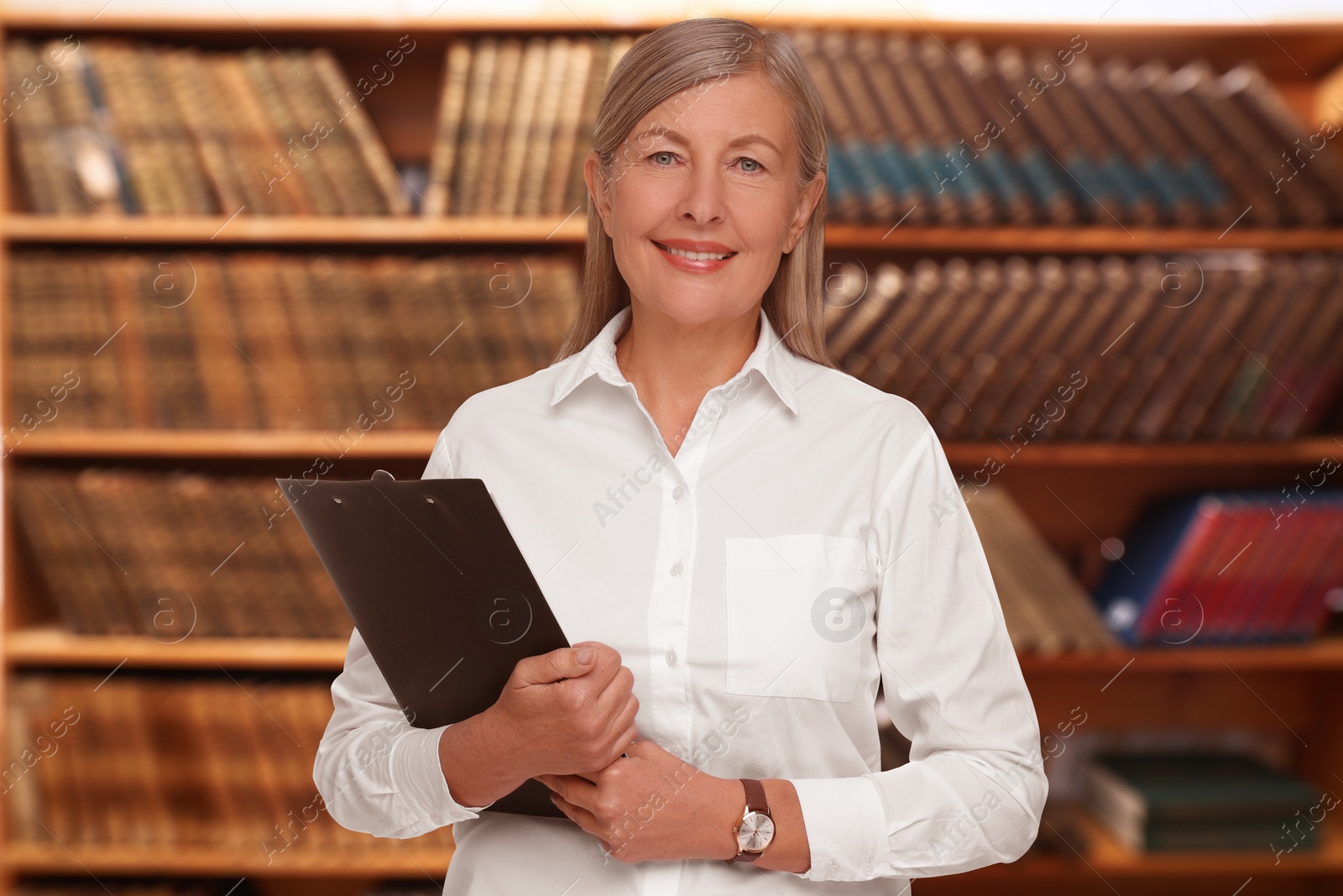 Image of Lawyer, consultant, business owner. Confident woman with clipboard smiling indoors