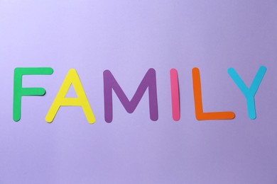 Word Family made of colorful paper letters on violet background, flat lay