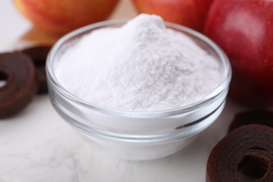 Photo of Sweet fructose powder, fruit leather rolls and apples on white marble table, closeup