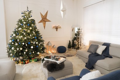 Cozy living room interior with beautiful Christmas tree and comfortable sofa