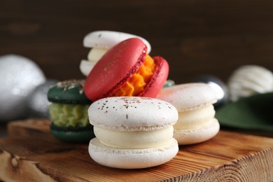Photo of Beautifully decorated Christmas macarons and festive decor on wooden table, closeup