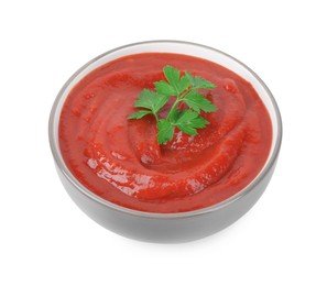 Photo of Organic ketchup and parsley in bowl isolated on white. Tomato sauce