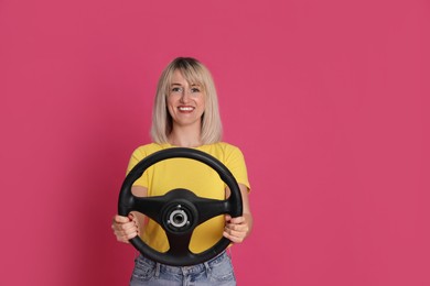 Photo of Happy woman with steering wheel on crimson background. Space for text