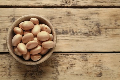 Photo of Raw jackfruit seeds on wooden table, top view. Space for text