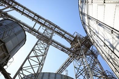 Modern granaries for storing cereal grains against blue sky, low angle view