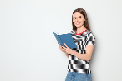 Photo of Young woman reading book on white background, space for text