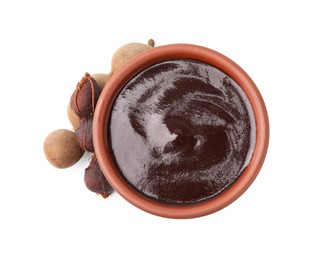 Photo of Bowl of tamarind sauce and fresh pods isolated on white, top view