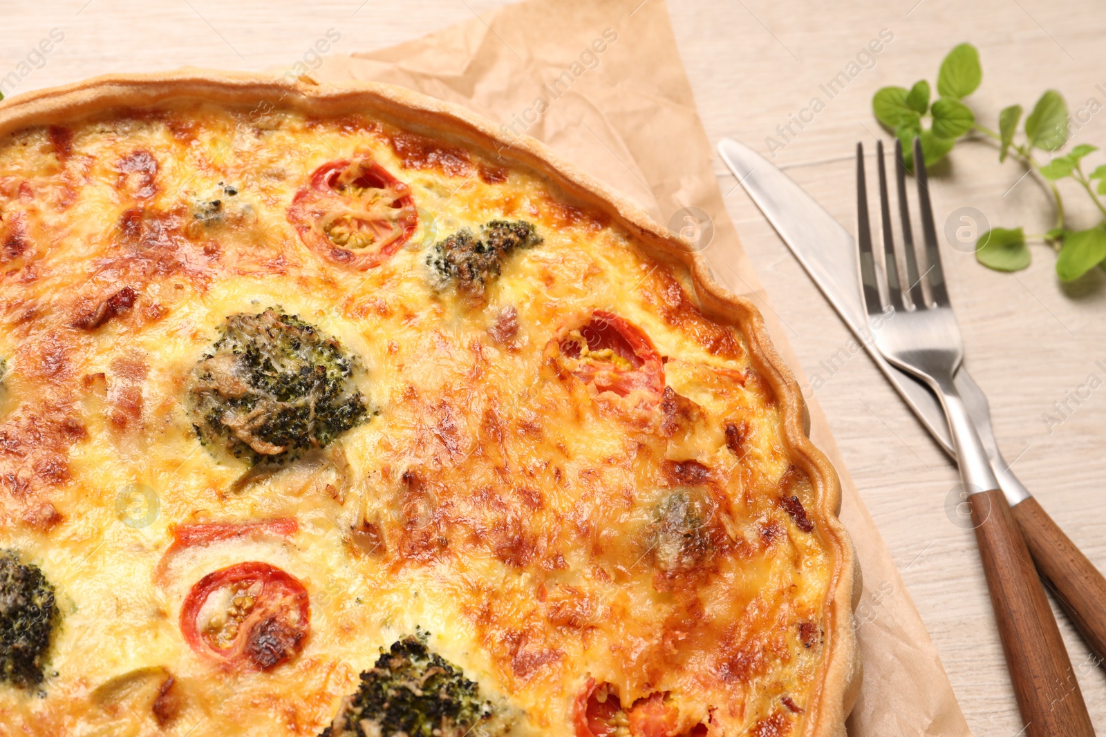 Photo of Delicious homemade vegetable quiche and cutlery on table, closeup