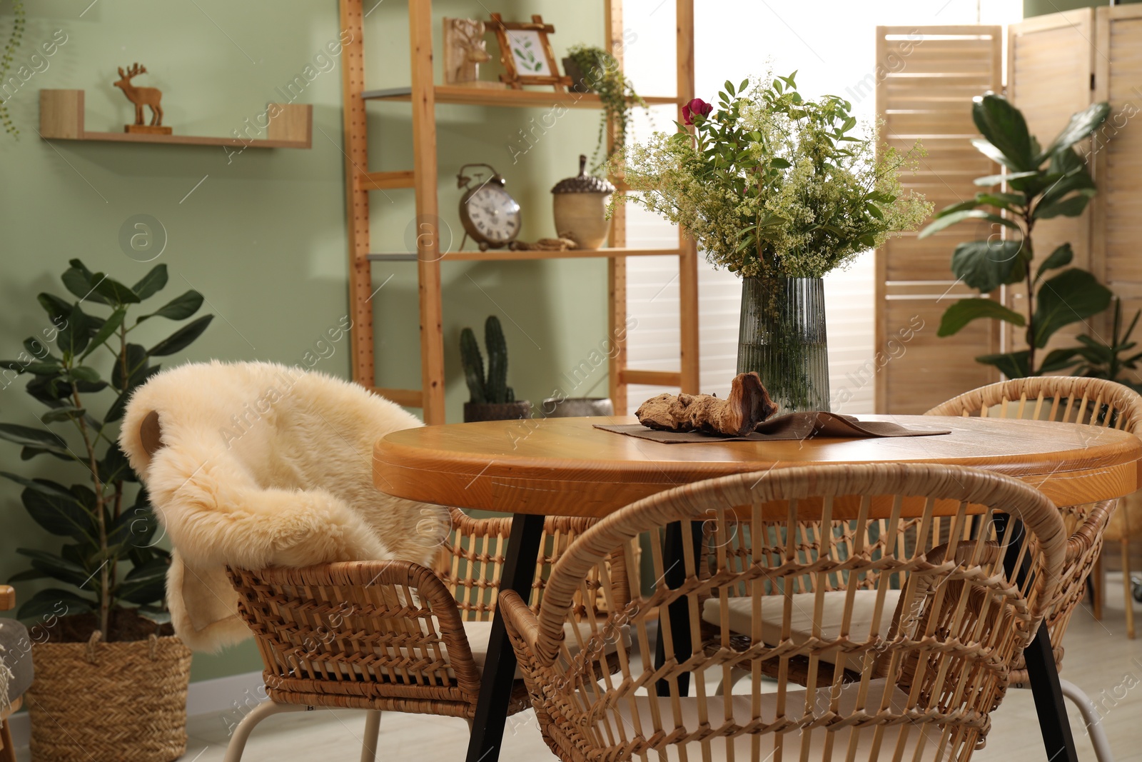 Photo of Stylish dining room interior with wooden table and rattan chairs