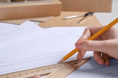 Photo of Woman creating packaging design at table, closeup