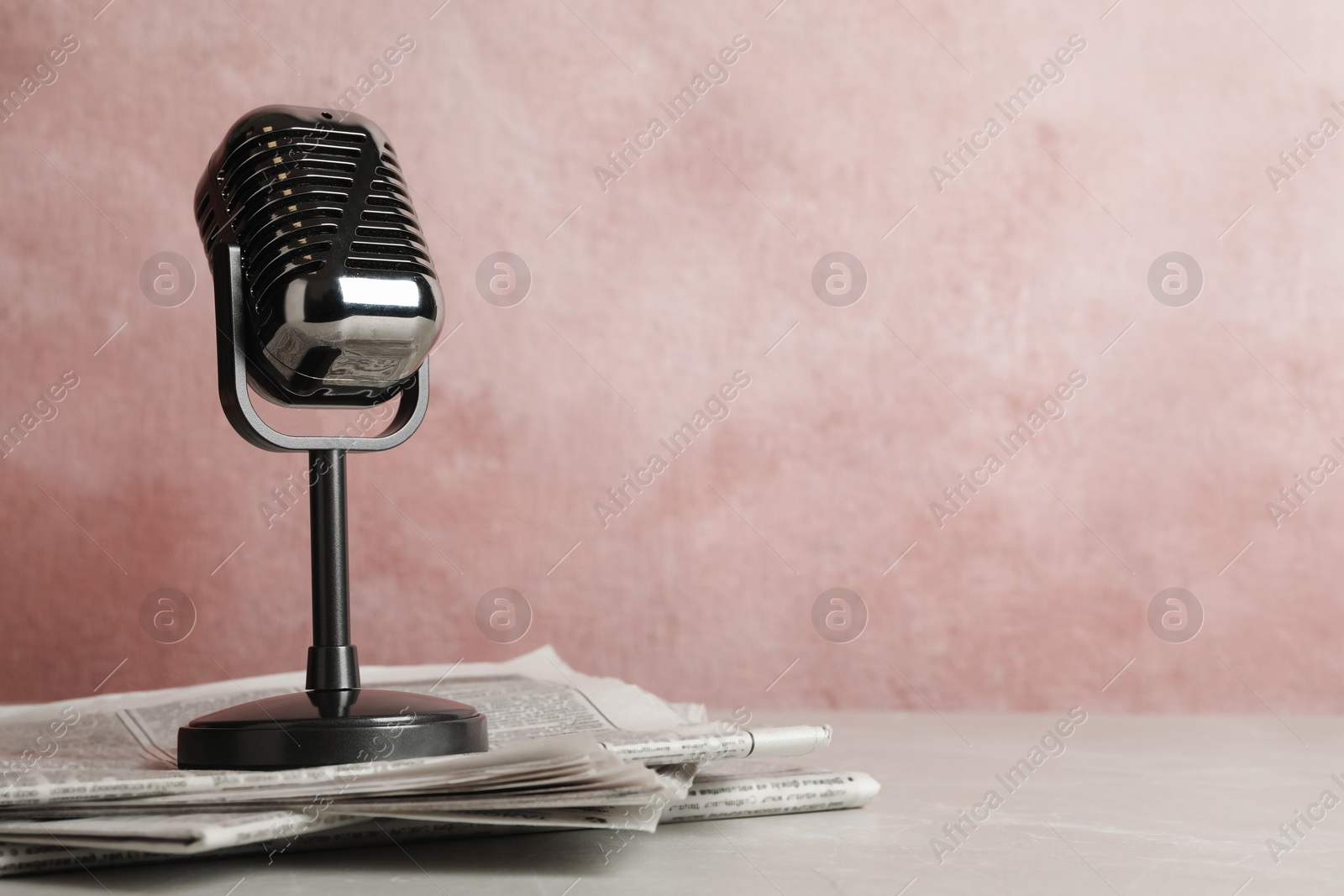 Photo of Newspapers and vintage microphone on table, space for text. Journalist's work
