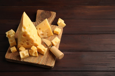 Delicious cheese and knife on wooden table. Space for text