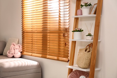 Stylish room interior with wooden ladder near white wall