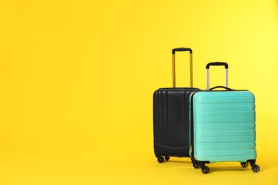 Photo of Stylish suitcases on color background. Space for text