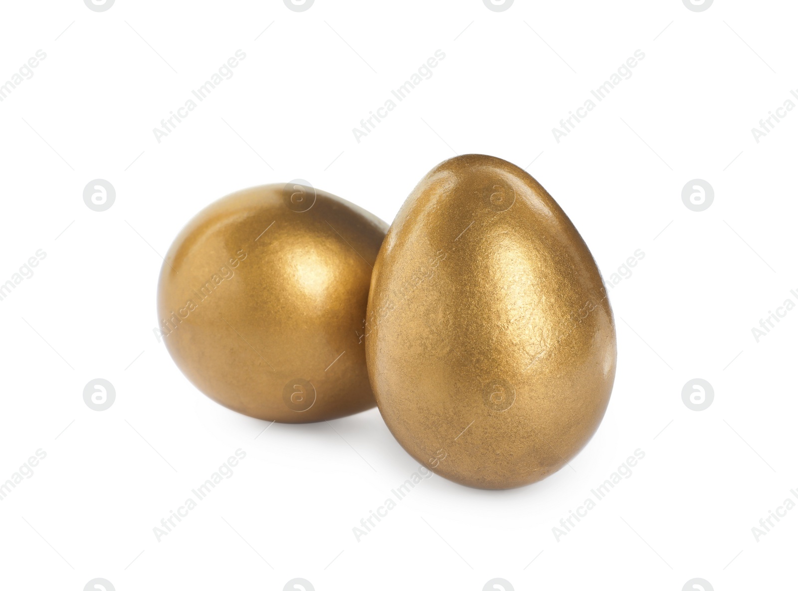 Photo of Two shiny golden eggs on white background