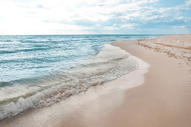 Photo of Sea waves rolling onto sandy tropical beach