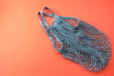 Photo of Blue string bag on red background, top view. Space for text