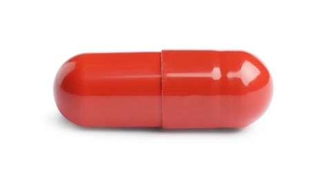 Photo of One red pill on white background. Medicinal treatment