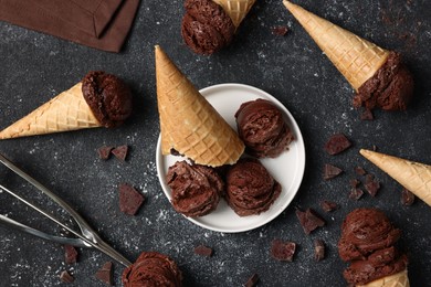 Flat lay composition with tasty ice cream scoops in waffle cones on dark textured table