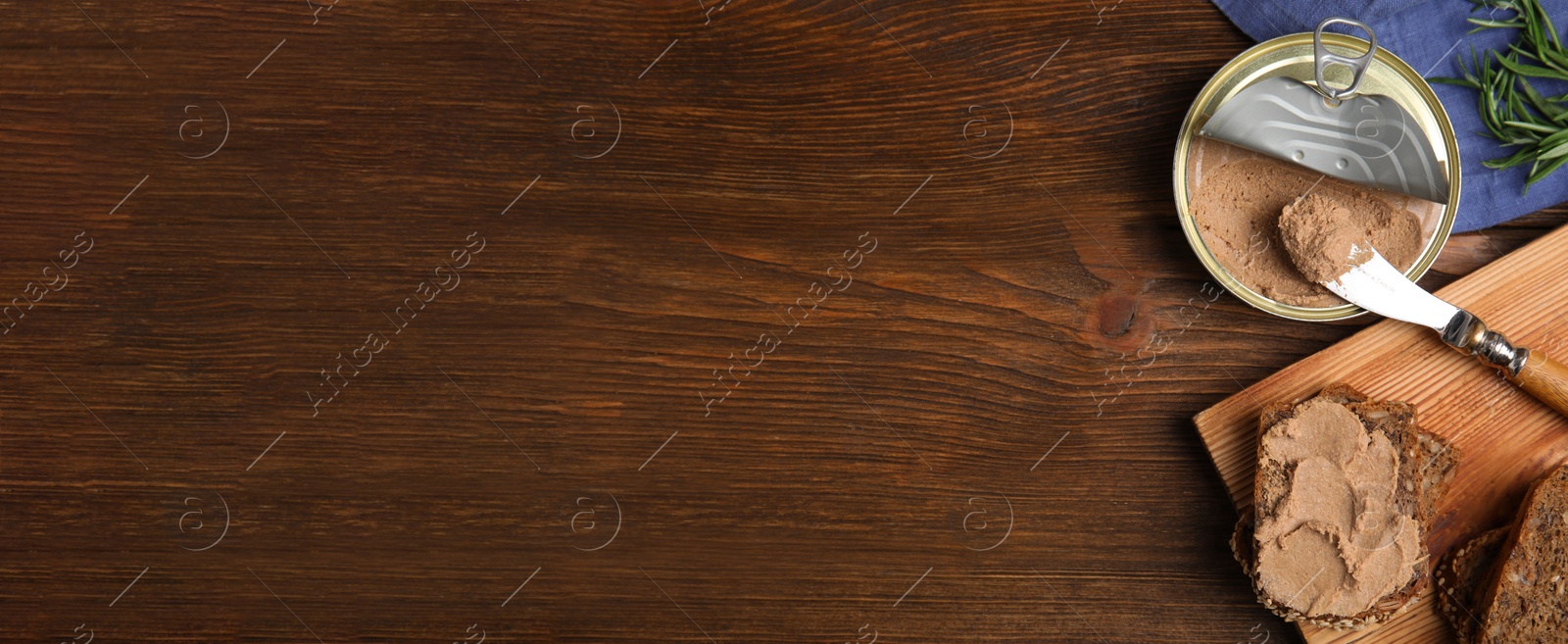 Image of Tin can with delicious pate and slices of bread on wooden table, flat lay. Banner design with space for text