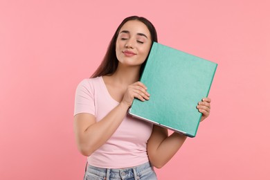 Woman with green folder on pink background
