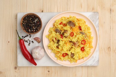 Delicious pilaf with meat and ingredients on wooden table, top view