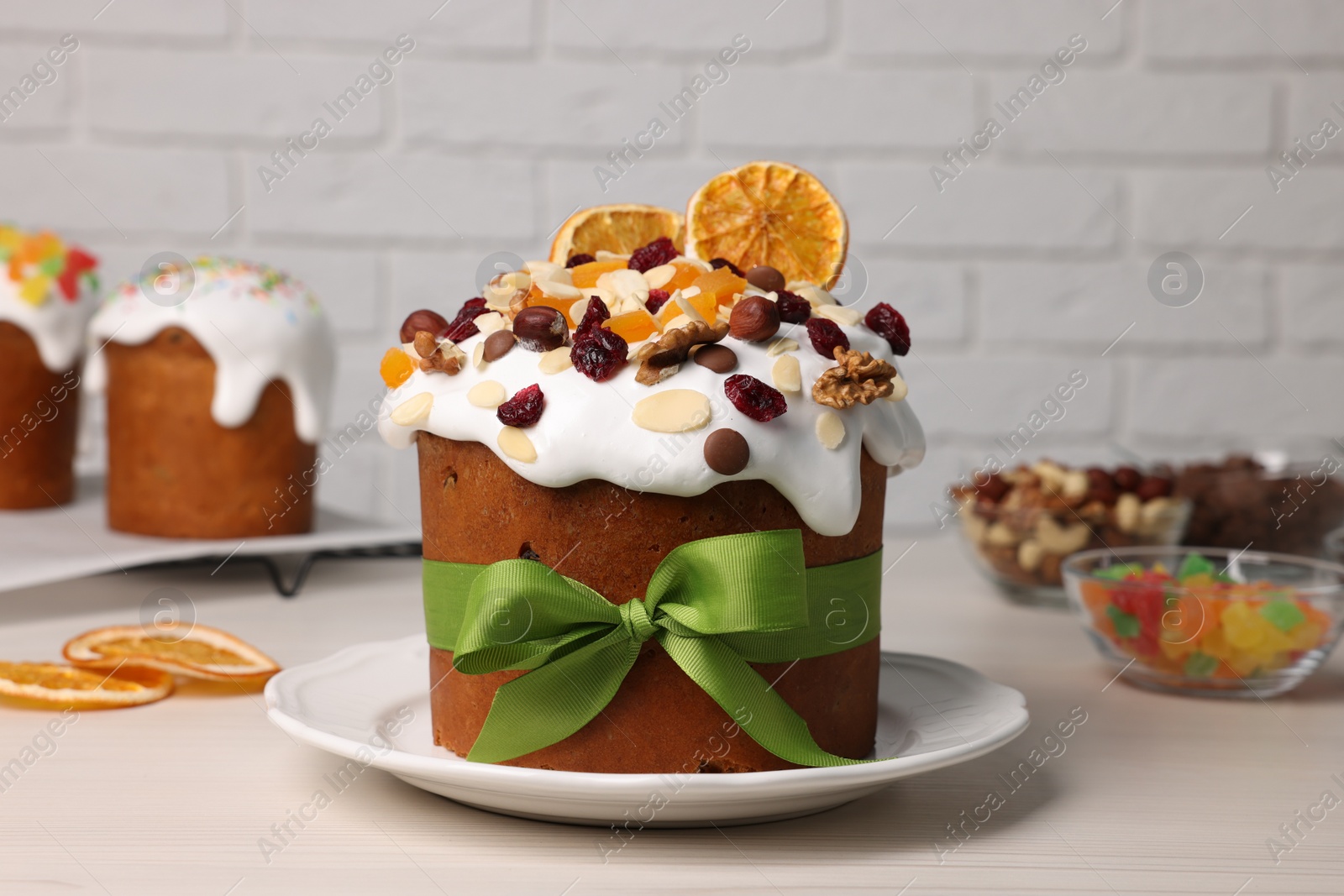 Photo of Tasty Easter cakes with dried fruits and nuts on white wooden table