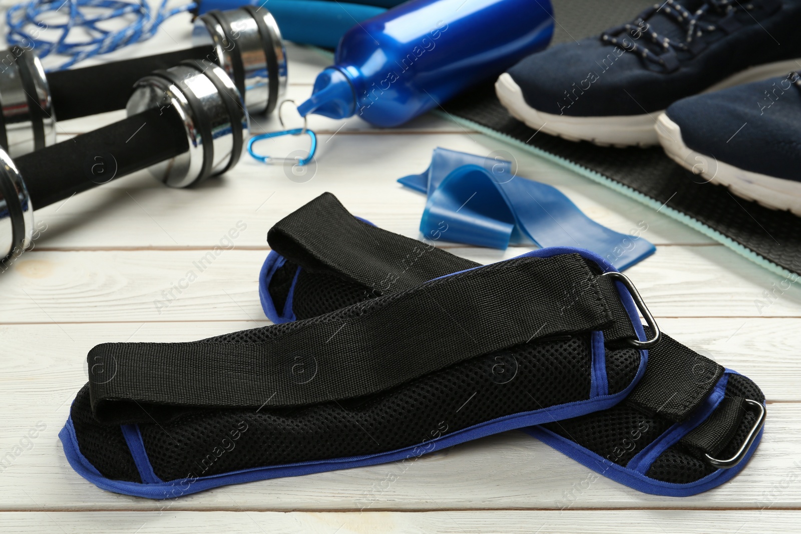 Photo of Blue weighting agents and sport equipment on white wooden table