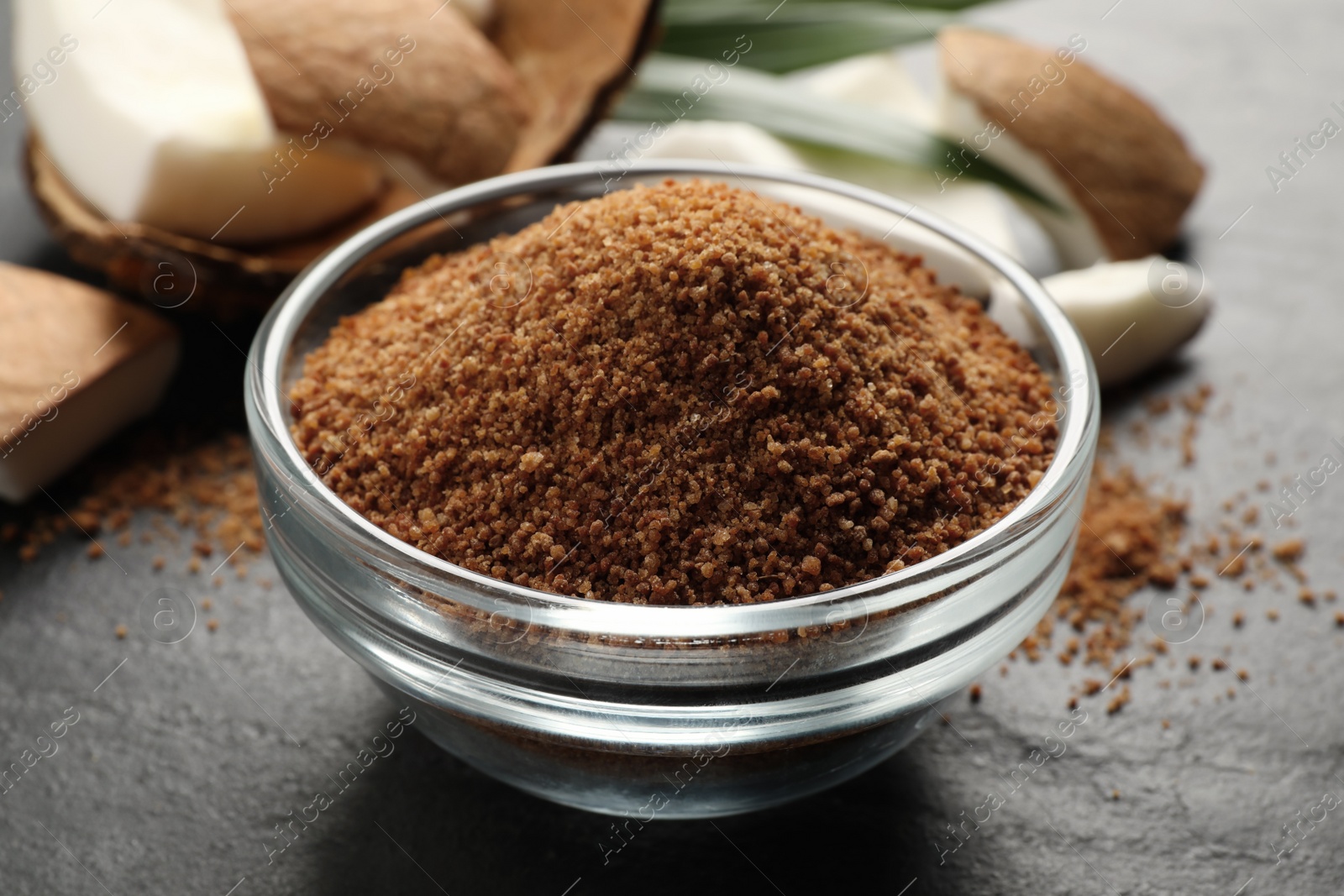 Photo of Natural coconut sugar in glass bowl on black table