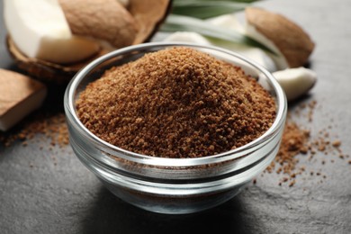 Natural coconut sugar in glass bowl on black table