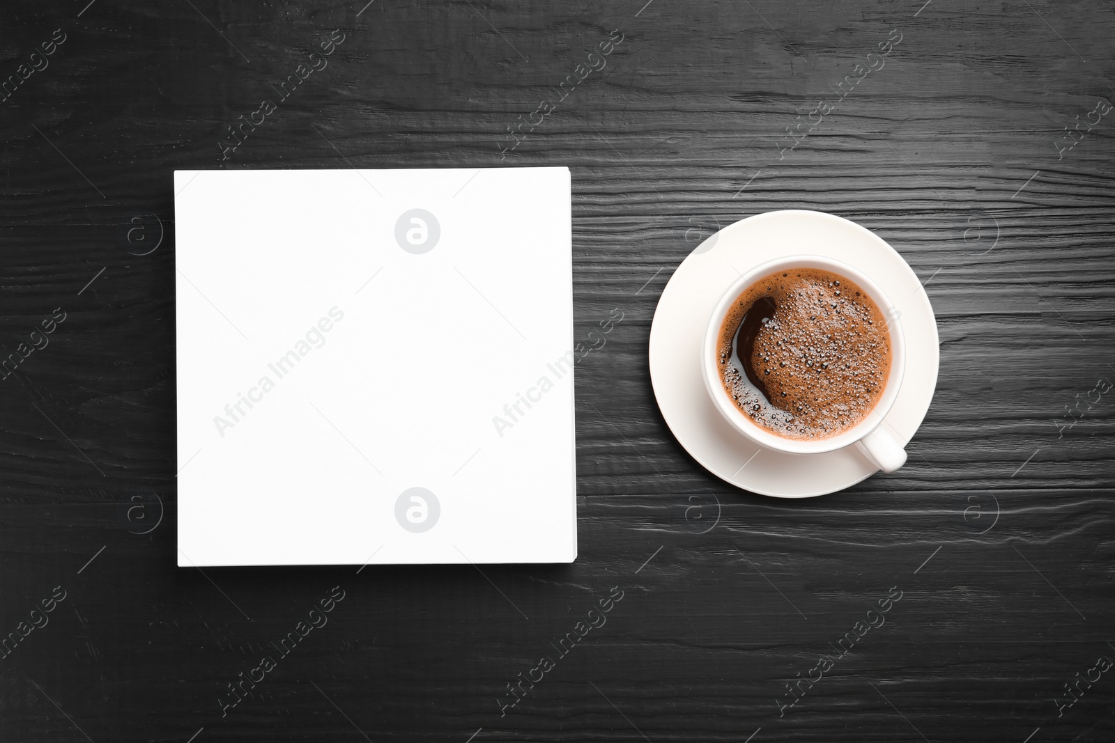 Photo of Blank paper sheets for brochure and cup of coffee on black wooden background, flat lay. Mock up