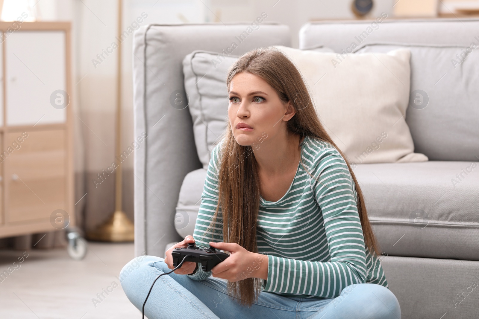 Photo of Emotional young woman playing video games at home