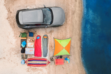 Car and camping equipment on sandy beach, aerial view. Summer trip