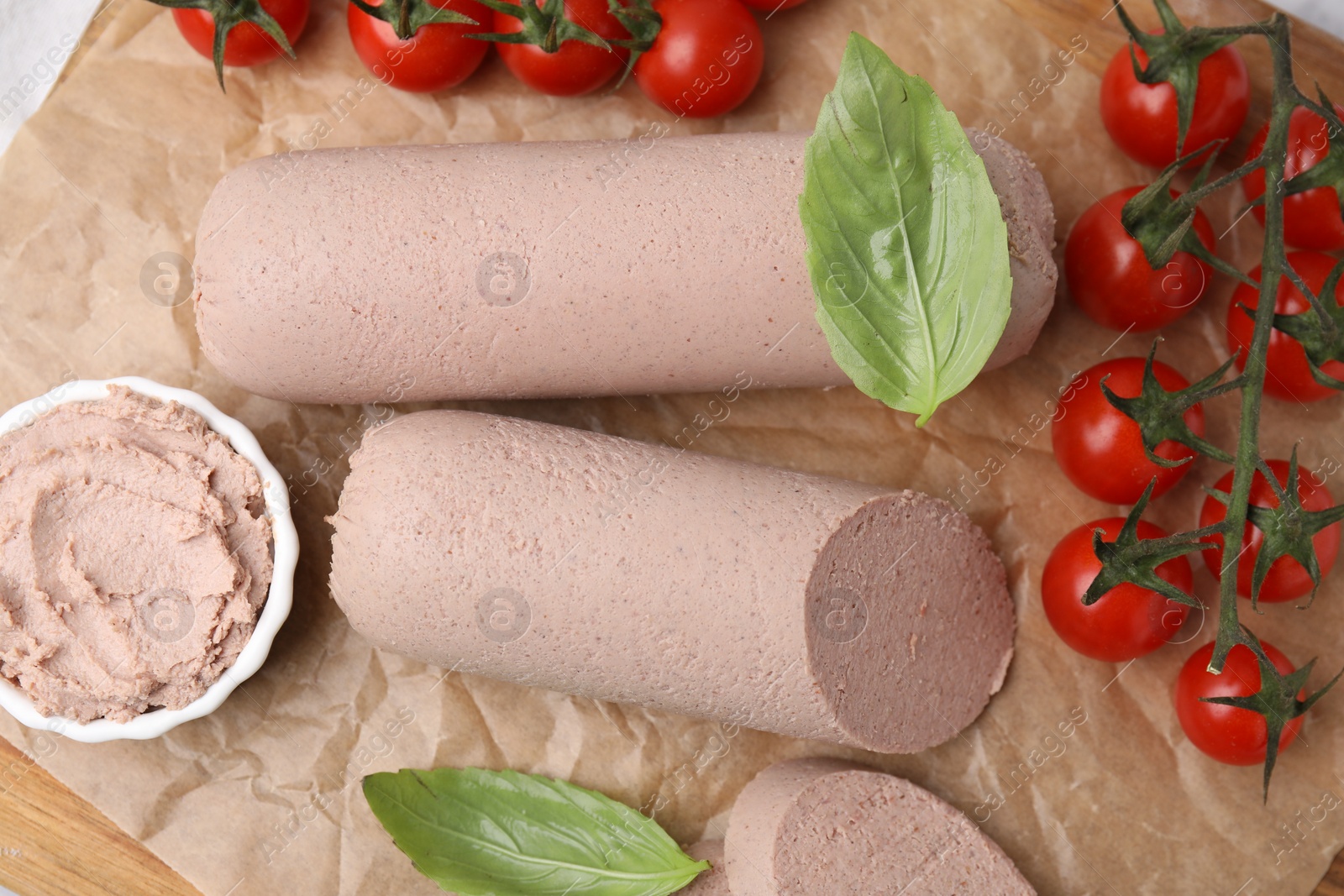 Photo of Delicious liver sausages, paste and cherry tomatoes on table, flat lay