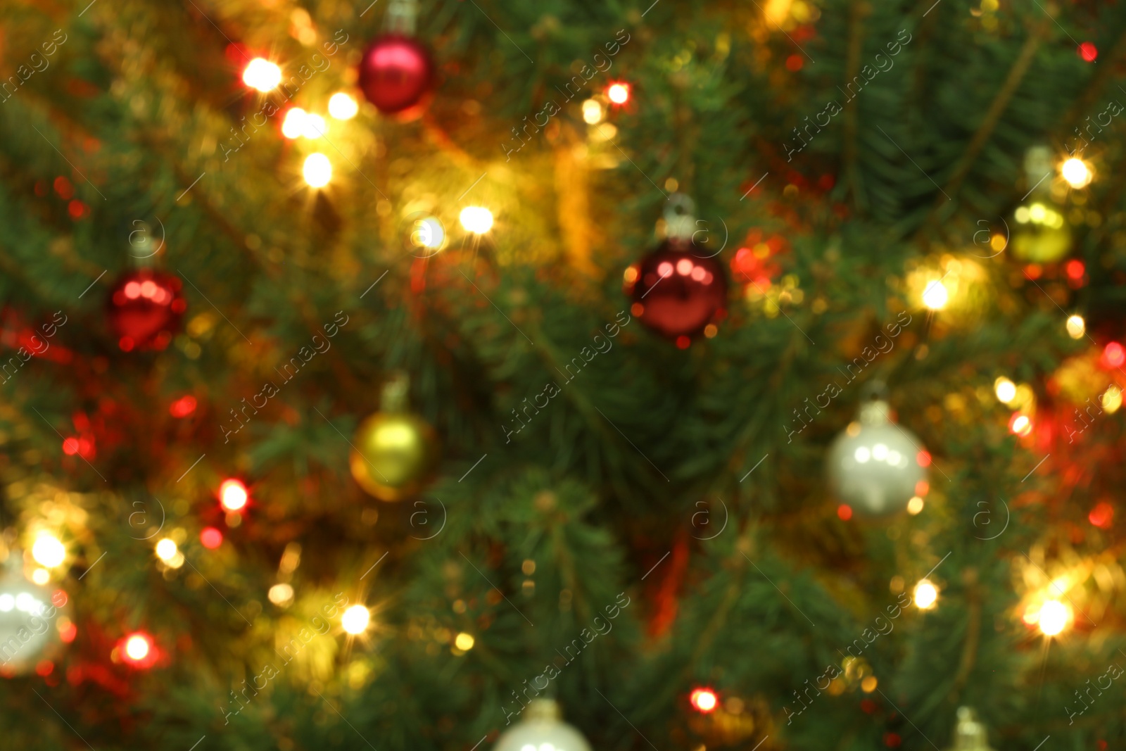 Photo of Blurred view of glowing fairy lights and beautiful baubles on Christmas tree