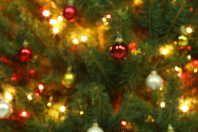 Photo of Blurred view of glowing fairy lights and beautiful baubles on Christmas tree