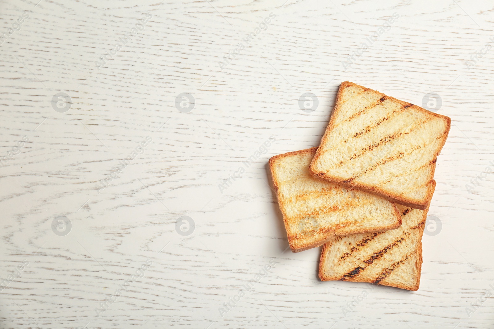 Photo of Toasted bread on light background, top view