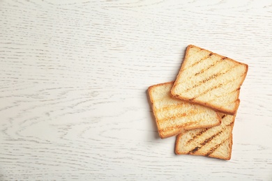 Toasted bread on light background, top view