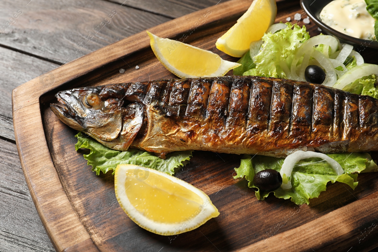 Photo of Wooden board with delicious grilled fish, closeup