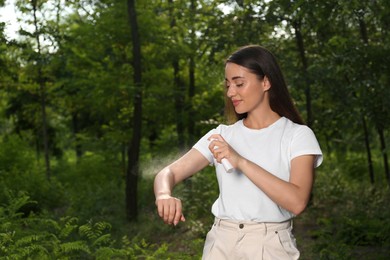 Photo of Woman applying insect repellent on arm in park. Tick bites prevention