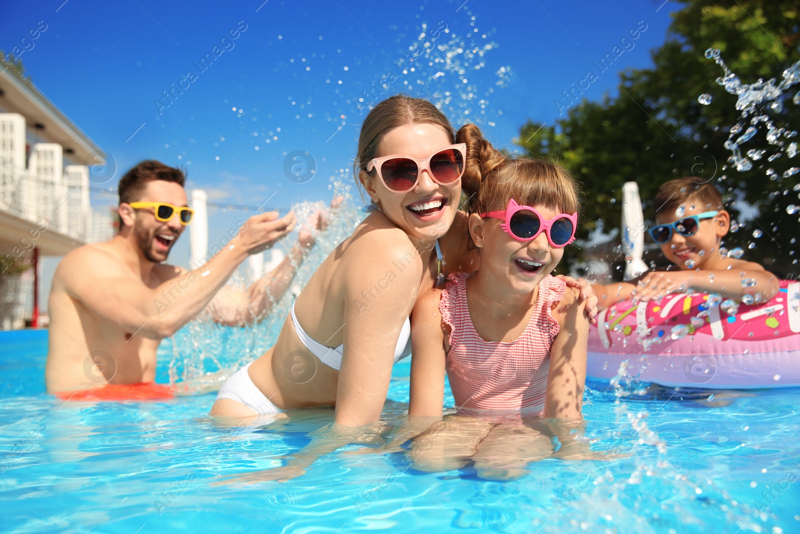 Photo of Happy family having fun in swimming pool