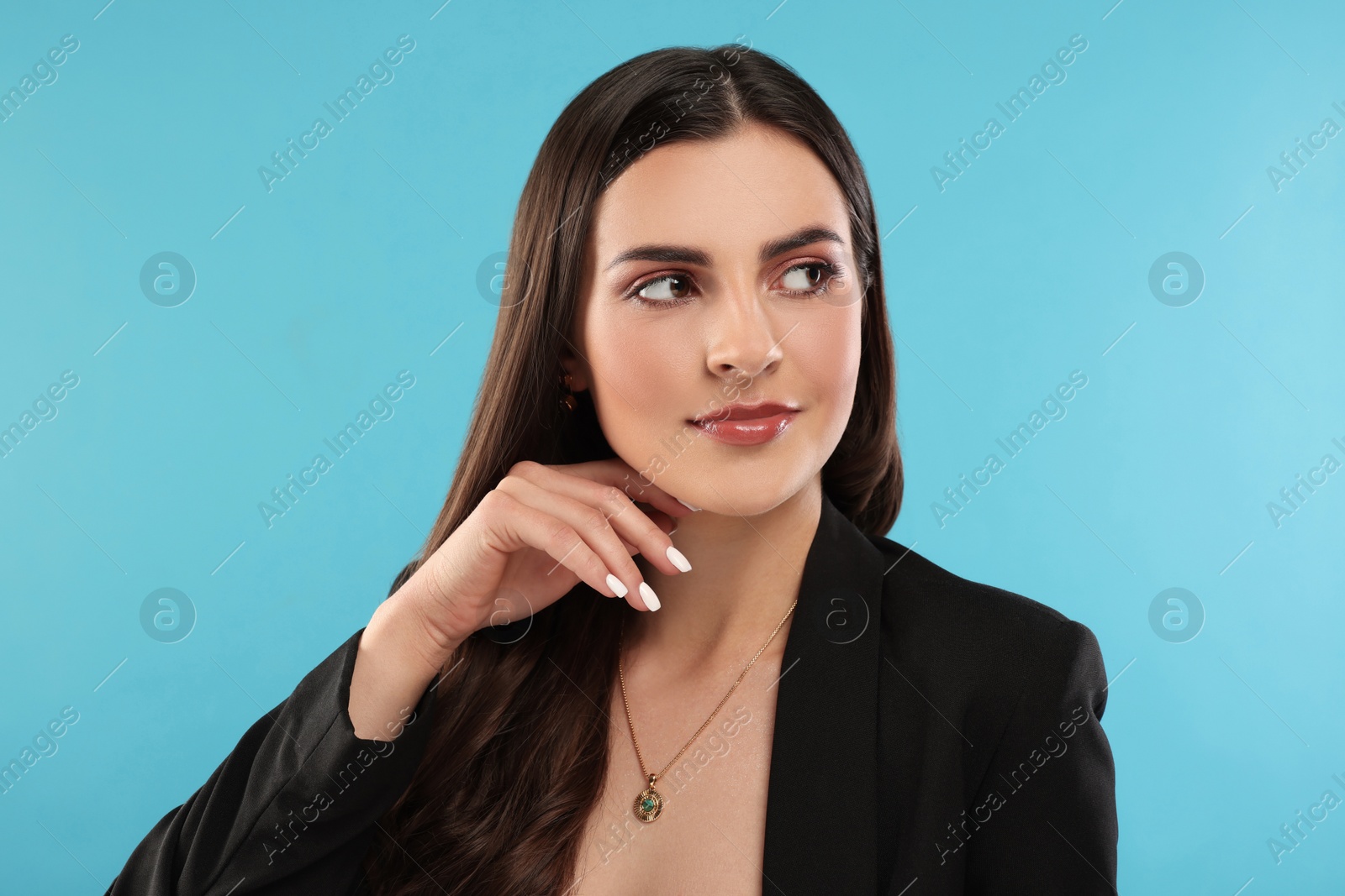 Photo of Beautiful woman with elegant jewelry on light blue background