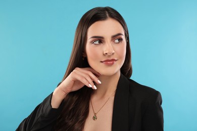 Beautiful woman with elegant jewelry on light blue background