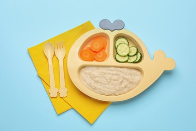 Photo of Healthy baby food in plate on light blue background, flat lay